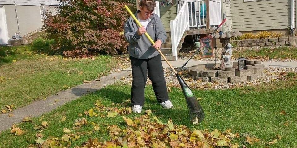 Tasha raking leaves in front of her home.