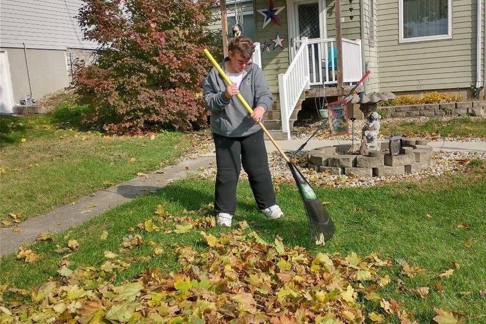 Tasha raking leaves in front of her home.